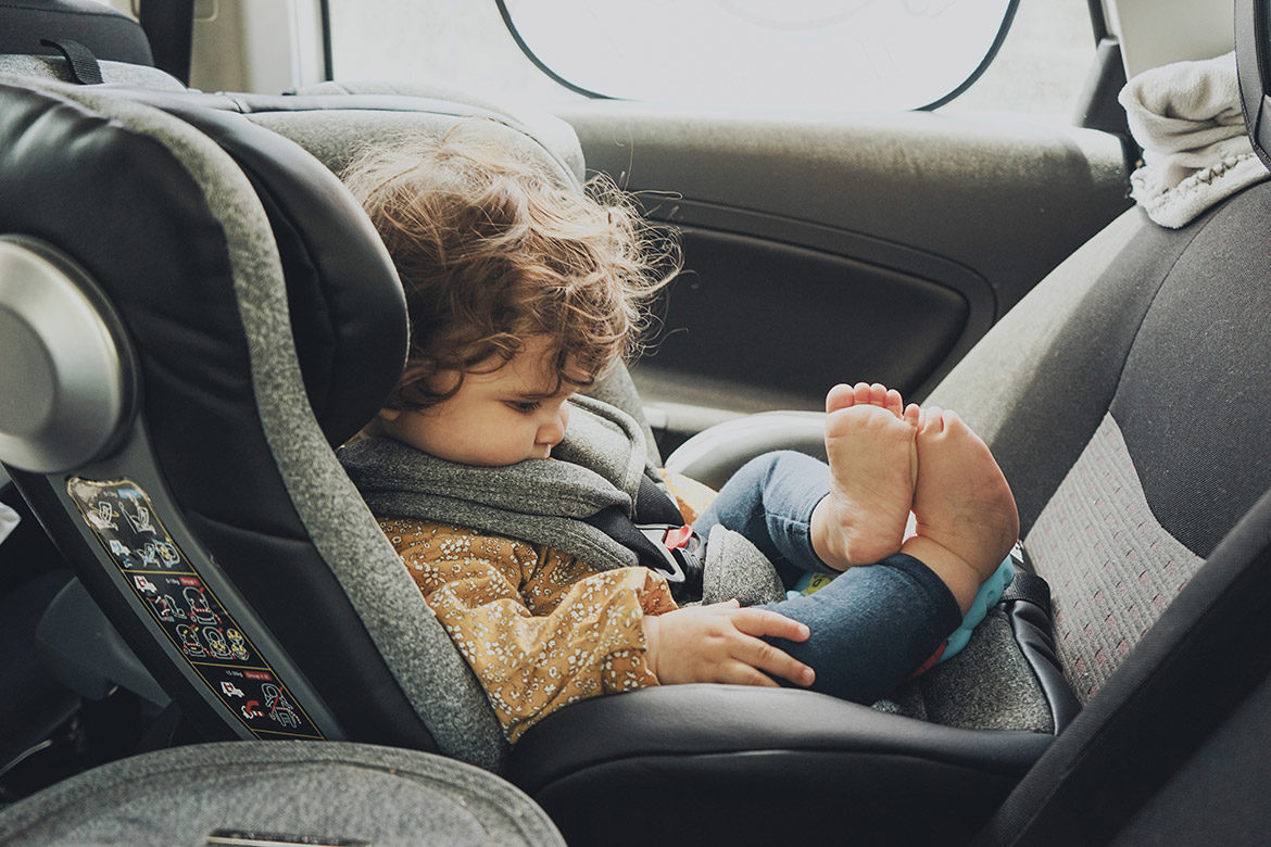 Bébé installé dos à la route dans un siège auto i-Size avec harnais bien ajusté
