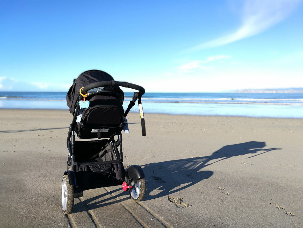 Poussette sur le sable en bord de mer avec de grandes roues adaptées à une utilisation tout-terrain