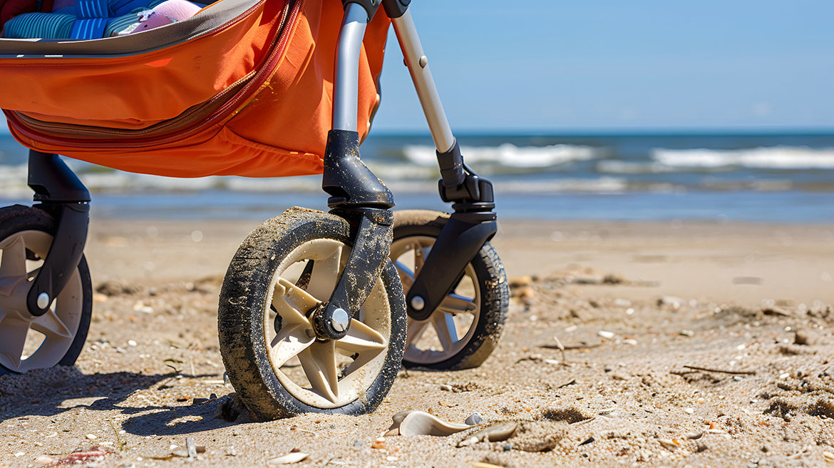 Gros plan sur les grandes roues d'une poussette tout-terrain dans le sable