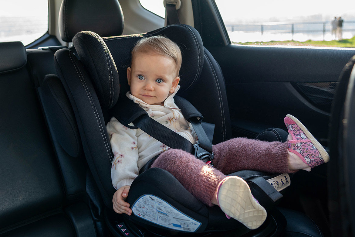 Bébé installé dans un siège auto avec des vêtements chauds et fins, harnais bien ajusté