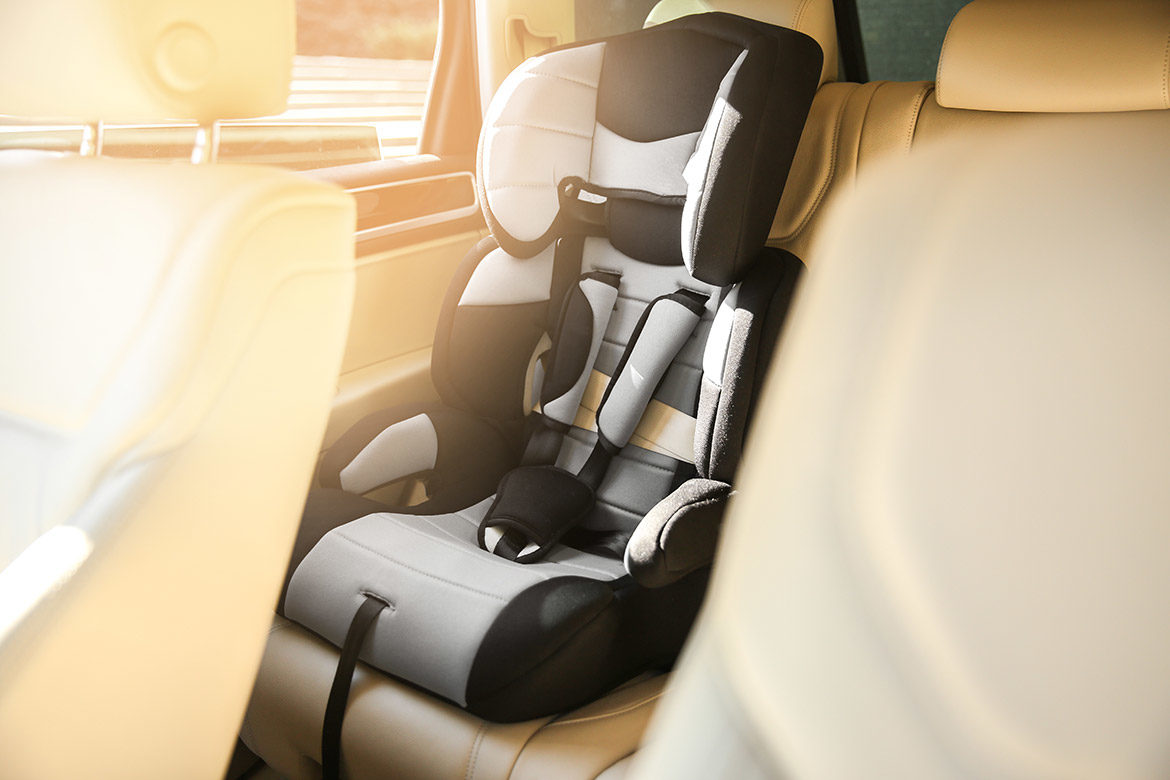 Siège auto enfant rehausseur installé à l’arrière d’un véhicule de type VTC ou taxi.