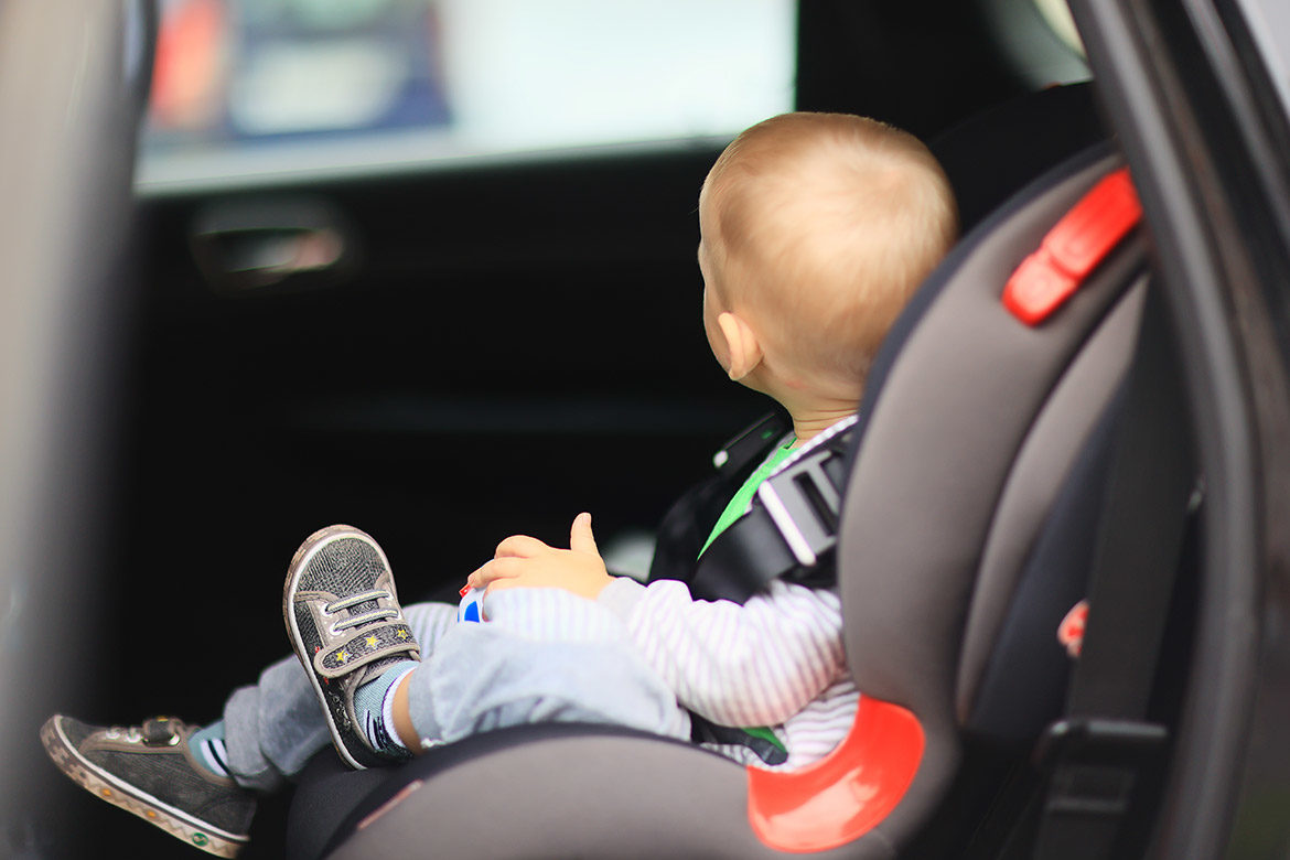 Enfant en bas âge assis dans un siège auto, dans une voiture