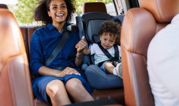 Maman souriante et bébé en siège auto lors d’un trajet en VTC ou taxi